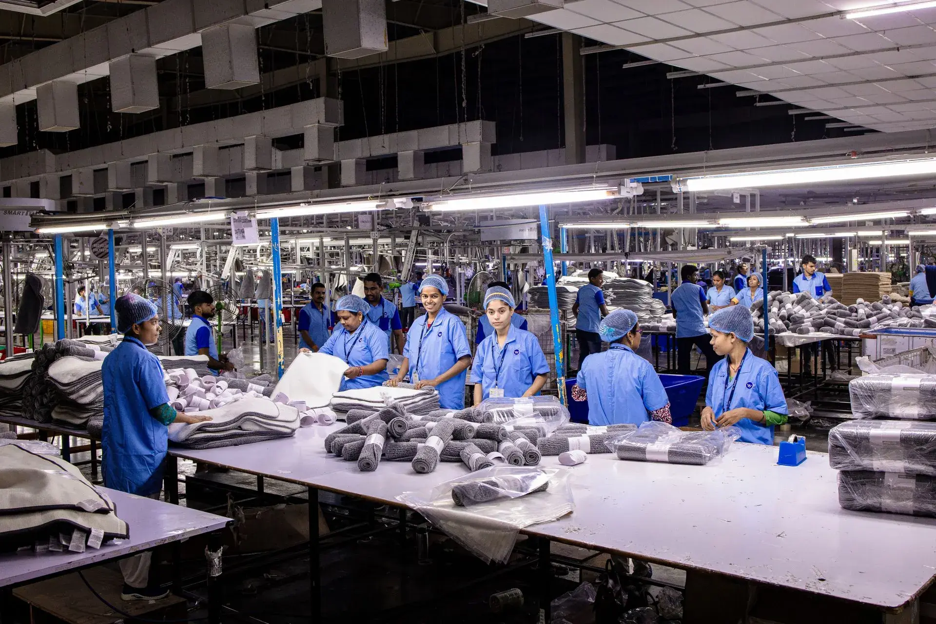 Garment factory sewing floor with rows of operators at industrial machines